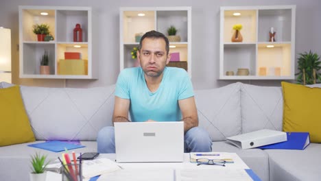 Home-office-worker-man-looking-at-camera-depressed.